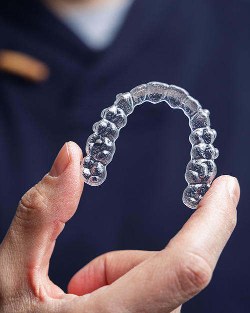 orthodontist holding a pair of clear aligners
